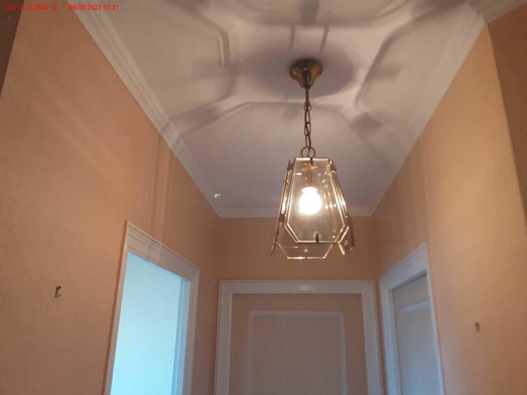 Plafond repeint et lustre reposé après traitement des traces d'humidité