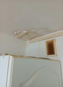 Peinture cloquée et murs abîmés par l'humidité dans une cuisine